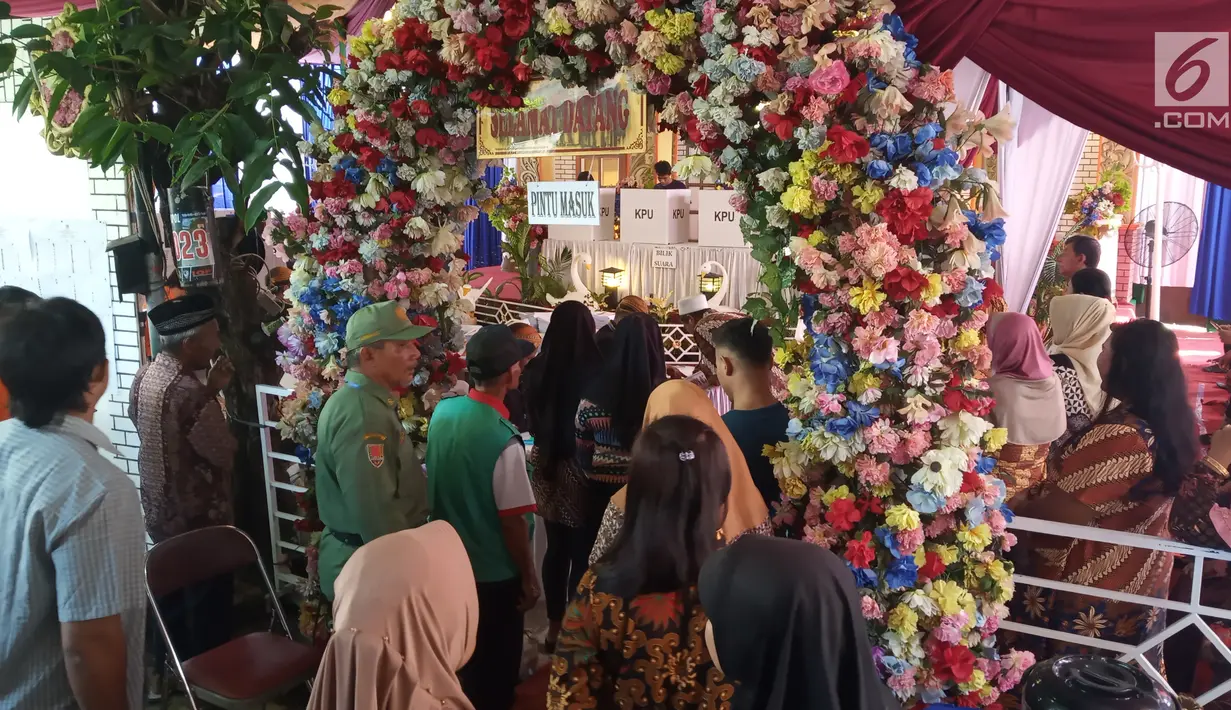 Warga antre memberikan hak suaranya di TPS 09 Kelurahan Sambirejo yang berkonsep pesta pernikahan di Semarang, Jawa Tengah, Rabu (17/4). TPS itu dihiasi dengan dekorasi mewah dan menarik layaknya tempat pesta pernikahan agar semua warga senang ketika datang untuk mencoblos. (Liputan6.com/Gholib)