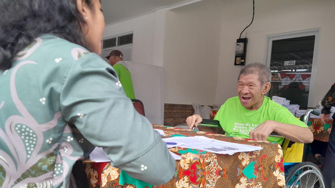 Salah satu opa penghuni Panti Werdha Bina Bhakti Tangerang Selatan sedang mendaftarkan diri sebelum mencoblos.