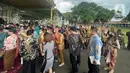 Sejumlah warga mengantre untuk bersalaman dengan putra bungsu Presiden Joko Widodo, Kaesang Pangarep dan istrinya Erina Gudono pada acara Ngunduh Mantu pernikahan di Pura Mangkunegaran, Solo, Minggu (11/12/2022). Antrean tamu undangan yang ingin berfoto dengan Kaesang Pangarep dan Erina Gudono beserta keluarga mengular panjang bahkan rela berdesak-desakan demi bisa berfoto dengan kedua mempelai. (Liputan6.com/Herman Zakharia)