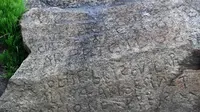 Saat surut, sebuah batu bertuliskan kode berumur 230 tahun muncul di sebuah pantai di Prancis. (FRED TANNEAU / AFP)