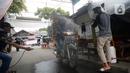 Sejumlah pemuda menyemprotkan cairan disinfektan kepada orang yang akan memasuki RW 10 di kawasan Tanah Kusir, Kelurahan Kebayoran Lama Selatan, Jakarta, Rabu (8/4/2020). Warga menerapkan akses satu pintu masuk pemukiman tersebut untuk mencegah penyebaran corona COVID-19. (merdeka.com/Dwi Narwoko)