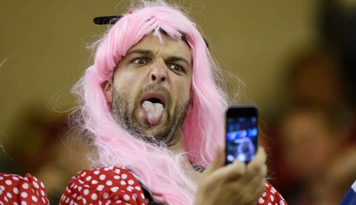 Seorang suporter mengunakan rambut palsu berselfie pada Piala Dunia Rugby 2015 antara Wales melawan Fiji di Millennium Stadium, Cardiff, Wales (1/10/2015). (Reuters/Rebecca Naden)