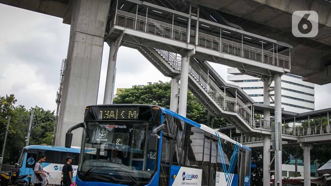 Bus Transjakarta melintas di bawah halte Transjakarta CSW di Jalan Sisingamangaraja, Jakarta, Rabu (15/1/2020). Untuk mencapai halte CSW yang setara dengan bangunan bertingkat 7 lantai tersebut harus melalui 117 anak tangga dengan ketinggian 20 meter. (Liputan6.com/Faizal Fanani)