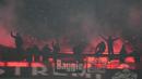 Beberapa pendukung AC Milan bersorak di depan suar yang menyala merayakan gol ke gawang Inter Milan pada laga pekan ke-33 Serie A Liga Italia 2023/2024 di San Siro Stadium, Milan, Senin (22/4/2024). (AP Photo/Luca Bruno)