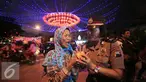 Seorang Polwan membagikan kue keranjang kepada pengguna jalan yang melintas di Pasar Gede, Solo (8/2). Pembagian kue keranjang imlek bertujuan mengkampanyekan anti narkoba dengan slogan, Kue Keranjang Lebih Manis Dari Narkoba. (Liputan6.com/Boy Harjanto)