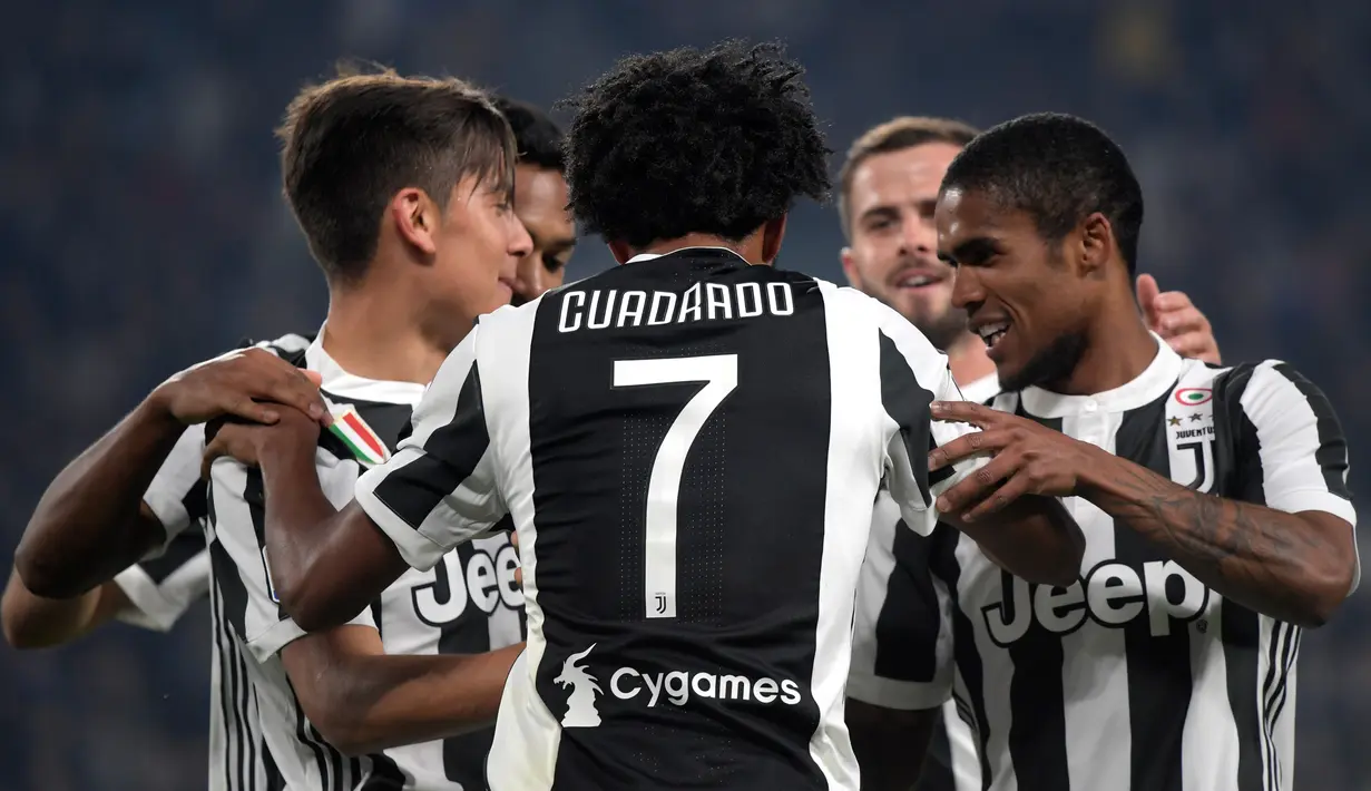 Pemain depan Juventus, Juan Cuadrado (tengah) dan rekan setimnya merayakan gol ke gawang SPAL pada lanjutan Serie A Italia di Allianz Stadium, Kamis (26/10). Menghadapi SPAL, "Si Nyonya Tua" mampu menang dengan skor telak 4-1. (MIGUEL MEDINA/AFP)