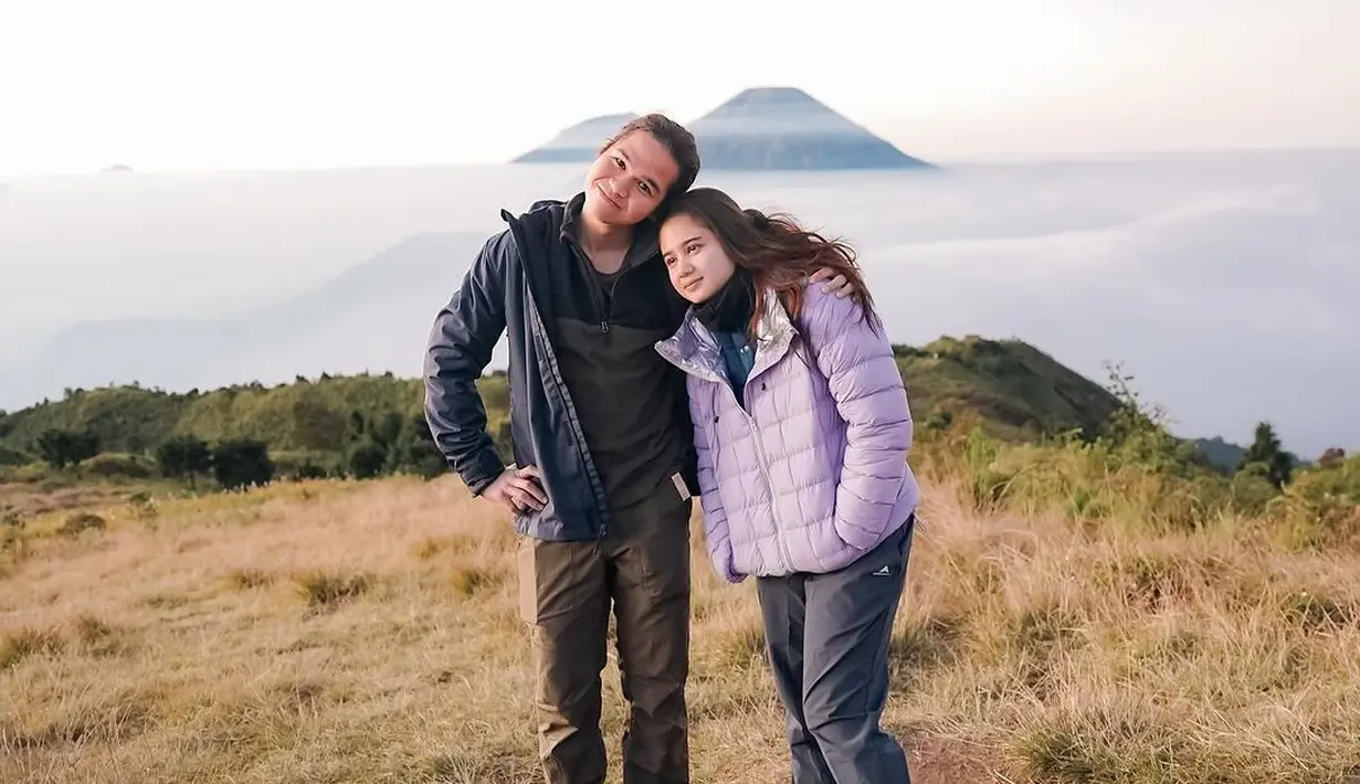 Gaya gemas keduanya naik gunung bersama. Dul tampil mengenakan polo shirt yang dilapisinya dengan jaket biru navy dan celana panjang cokelat, sedangkan Tissa Biani tampil mengenakan puffer jacket berwarna ungu dan celana panjang abu-abu. [Foto: Instagram/tissabiani]