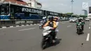 Pengendara sepeda motor melintas disebelah Bus Transjakarta yang mogok kerja di Halte Harmoni, Jakarta (12/6). (Liputan6.com/Gempur M Surya)