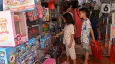 Warga memilih mainan yang dijual di Pasar Gembrong, Jakarta, Jumat (12/4/2024). Libur lebaran dimanfaatkan warga untuk berbelanja mainan. (Liputan6.com/Herman Zakharia)