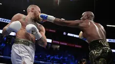 Floyd Mayweather mendaratkan pukulan tepat diwajah Conor McGregor dalam pertandingan tinju super kelas welter di Las Vegas (26/8). Mayweather berhasil mengalahkan McGregor dengan TKO. (AP Photo/Isaac Brekken)
