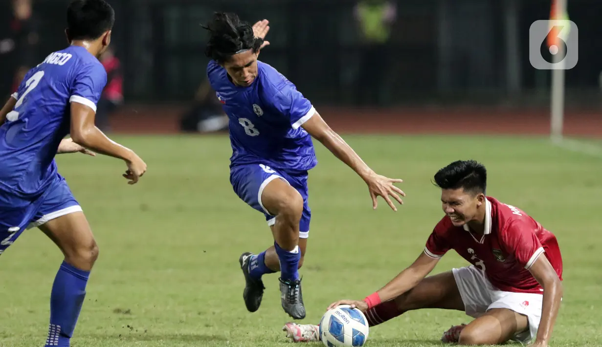 Pemain belakang Timnas Indonesia U-19, Kadek Arei Priyatna (kanan) terjatuh saat berebut bola dengan Kamil Jaser Rendon A (Filipina U-19) pada lanjutan penyisihan grup A Piala AFF U-19 2022 di Stadion Patriot Candrabhaga, Bekasi, Jawa Barat, Jumat (8/7/2022). Timnas Indonesia U-19 tampil menyerang dan unggul 5-1 atas Filipina U-19. (Liputan6.com/Helmi Fithriansyah)