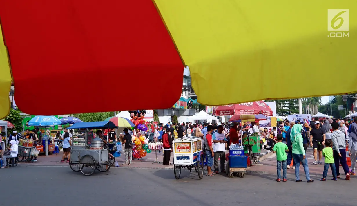 Pedagang kaki lima (PKL) tumpah ruah saat Car Free Day di kawasan Senayan, Jakarta, Minggu (8/10). Sebagian dari mereka menjajakan dagangannya di pendestrian hingga ke tengah jalan. (Liputan6.com/Fery Pradolo)