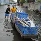 Sejumlah warga membawa ikan dengan gerobak melintasi banjir di Kawasan Muara Angke, Jakarta, Rabu (11/1). Banjir rob setiap laut pasang ini terjadi setelah tanggul laut jebol pada pertengahan tahun lalu. (Liputan6.com/Gempur M. Surya)