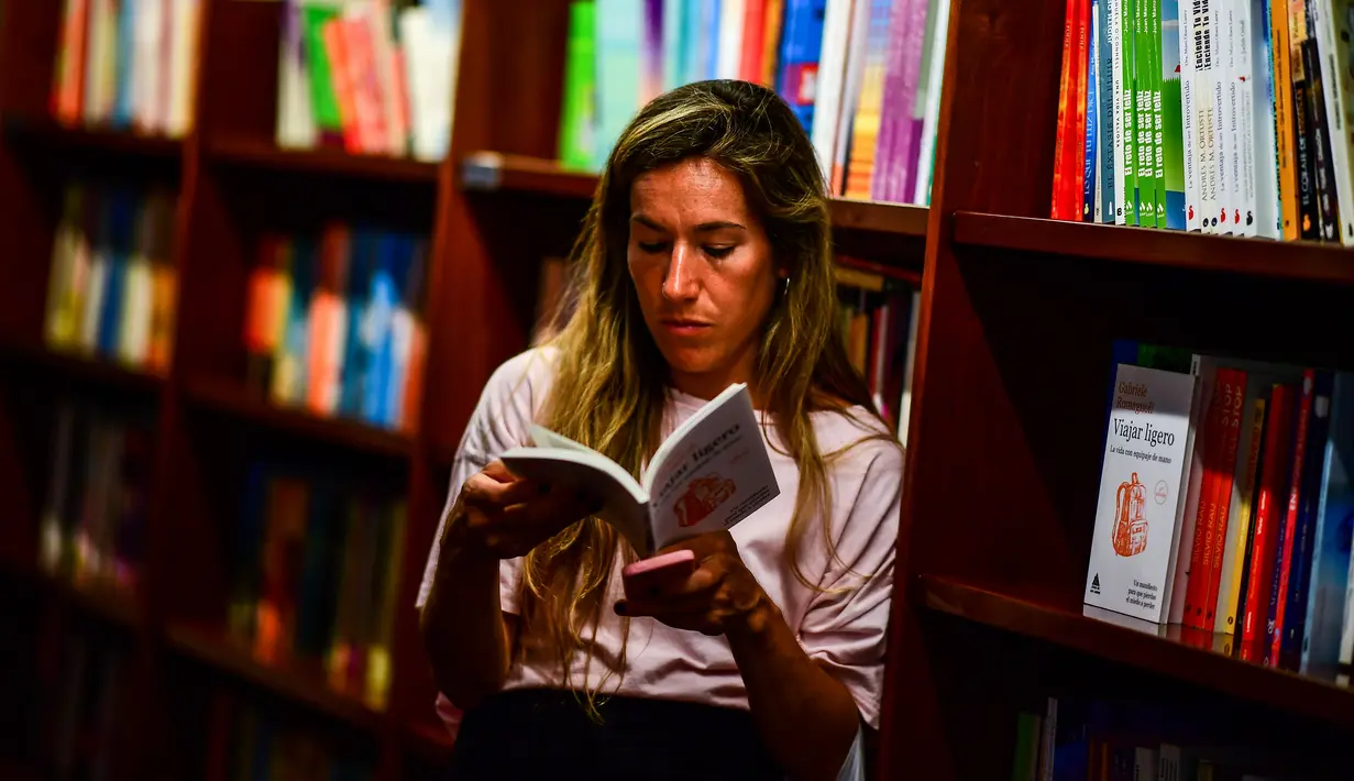 Seorang wanita membaca buku di toko buku "El Ateneo Grand Splendid" di Buenos Aires, Argentina pada Rabu (9/1). El Ateneo Grand Splendid adalah bangunan yang besar dan megah bekas gedung teater pada awal abad ke-20. (RONALDO SCHEMIDT / AFP)