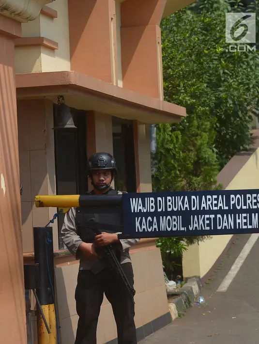 Seorang petugas bersenjata lengkap berjaga di depan pintu masuk Polres Jakarta Timur, Rabu (16/5). Pengamanan markas tersebut di perketat menyusul adanya penyerangan Mapolda Riau pada Rabu pagi. (Merdeka.com/Imam Buhori)