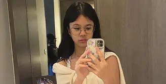 Tampil kekinian, kombinasi tank top dengan cardigan yang diikat sebagai luaran dan celana jeans bikin look makin stylish. [@shafeeamd_/@elelrumi].