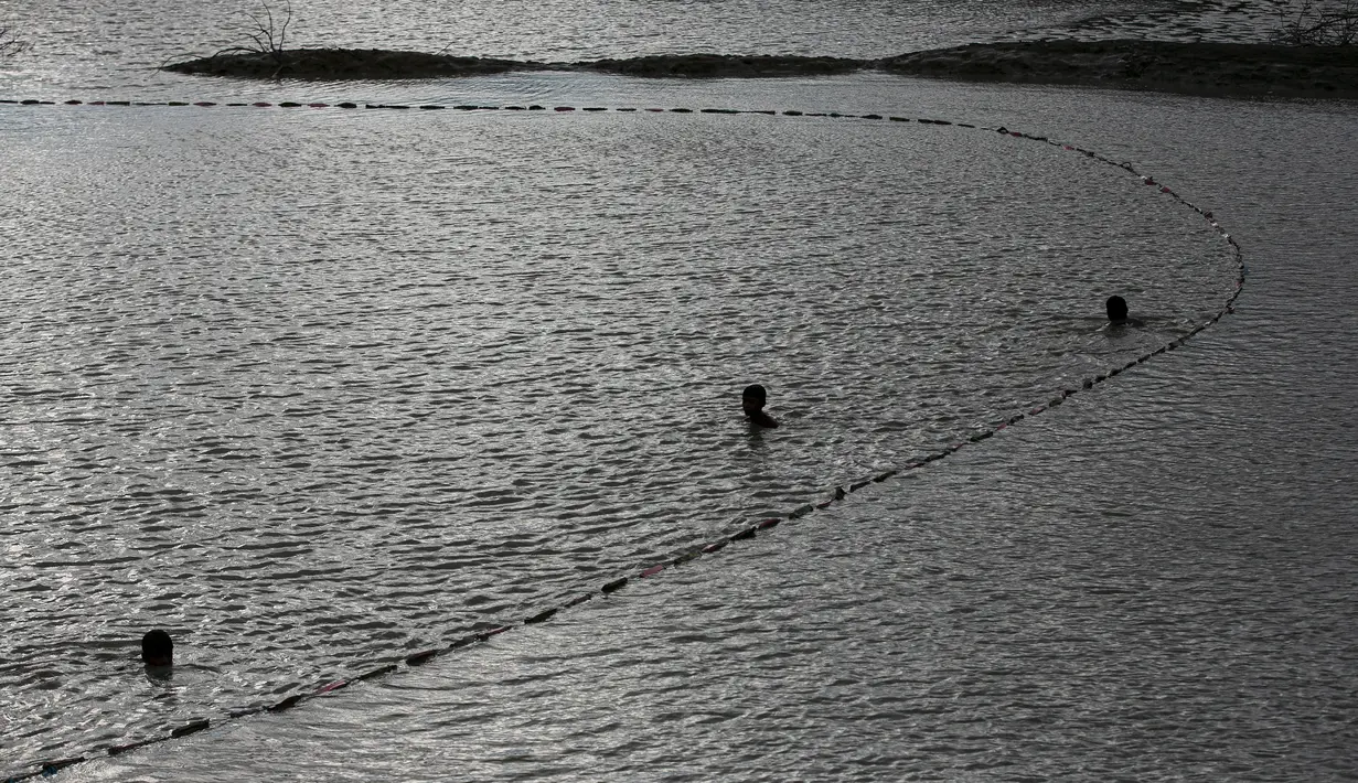 Dua nelayan India meletakkan jala ikan mereka saat senja di surutnya air banjir di sawah di pinggiran Gauhati, India, Senin, (14/9/2020). (AP Photo / Anupam Nath)