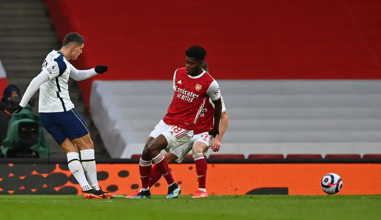 Gelandang Tottenham Hotspur Erik Lamela (kiri) menembak dengan tendangan teknik rabona untuk mencetak gol ke gawang Arsenal, Alexandre Lacazette dalam derby London Utara Liga Inggris di Emirates Stadium, Minggu (14/3/2021). Arsenal menang 2-1 atas Tottenham. (DAN MULLAN/POOL/AFP)