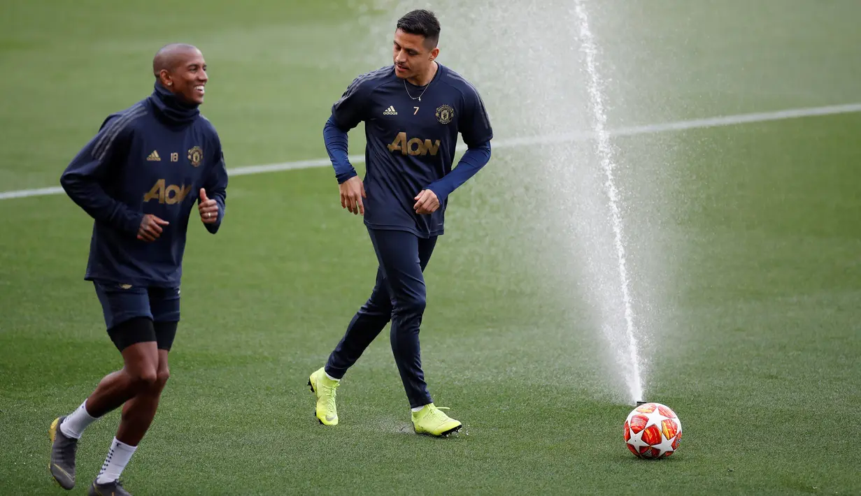 Penyerang Manchester United, Alexis Sanchez (kanan) berbincang dengan Ashley Young saat berlatih bersama jelang menghadapi Barcelona pada leg kedua babak perempat final Liga Champions 2018/19 di Stadion Camp Nou, Barcelona, Senin (15/4). (Reuters/Carl Recine)