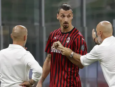 Pelatih AC Milan, Stefano Pioli, berusaha menenangkan Zlatan Ibrahimovic yang kecewa usai diganti saat melawan Bologna pada laga Serie A di Stadion San Siro, Sabtu (18/7/2020). AC Milan menang dengan 5-1 atas Bologna. (AP/Luca Bruno)
