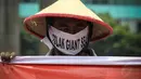 Seorang pengunjuk rasa tampak memakai penutup wajah yang bertuliskan tolak Giant Sea Wall, Jakarta, (15/10/14).(Liputan6.com/Faizal Fanani)