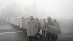 Polisi anti huru hara berjalan untuk menghadang demonstran selama protes di Almaty, Kazakhstan, Rabu (5/2/2022). Demonstran yang mencela kenaikan harga gas cair bentrok dengan polisi di kota terbesar Kazakhstan dan mengadakan protes di sekitar selusin kota lain di negara.(AP Photo/Vladimir Tretyakov