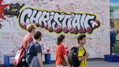 Pejalan kaki melintasi mural berisi harapan untuk gelandang timnas Denmark Christian Eriksen di dinding fanzone di Kopenhagen, Senin (14/6/2021). Eriksen mengalami serangan jantung dan sempat tak sadarkan diri saat memperkuat timnas Denmark vs Finlandia di Euro 2020. (AP Photo/Martin Meissner)