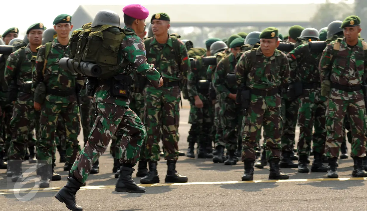 Seorang prajurit TNI yang tergabung dalam Satgas Pemadaman Kebakaran Hutan dan Lahan berlari bersiap berangkat menuju Sumatera Selatan dari Lanud Halim Perdanakusuma Jakarta, Kamis (22/10/2015). (Liputan6.com/Helmi Fithriansyah)