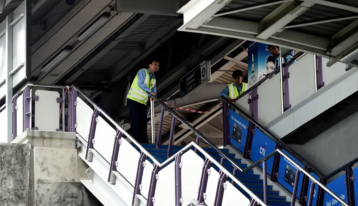 Pekerja di stasiun kereta berjaga di area stasiun setelah ledakan di Bangkok (2/8/2019). Polisi setempat menduga ledakan bersumber dari benda yang diduga seperti bom rakitan di Distrik Suan Luang. Polisi kini masih menyelidiki penyebab ledakan low explosive itu. (AFP Photo/Lillian Suwanrumpha)