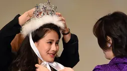 Mika Matsuno (kiri) menerima mahkota saat dinobatkan menjadi pemenang Miss Nippon 2016 di Tokyo, Jepang (25/1). Miko merupakan putri dari politikus Jepang Yorihisa Matsuno. (AFP PHOTO/Toshifumi Kitamura)