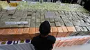 Petugas berjaga di dekat narkoba yang disita kepolisian Thailand dalam konferensi pers di Bangkok, Selasa (3/4). Polisi mengatakan 700 kilogram narkoba yang dikenal sebagai ice itu disita pada 28 Maret di Provinsi Chumpon selatan. (AP/Sakchai Lalit)
