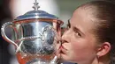  Jelena Ostapenko mencium trofi juara usai mengalahkan petenis Rumania, Simona Halep pada Final Prancis Terbuka 2017 di Roland Garros, Paris, (10/6/2017). Ostapenko menang 4-6, 6-4, 6-3. (AP/Christophe Ena)