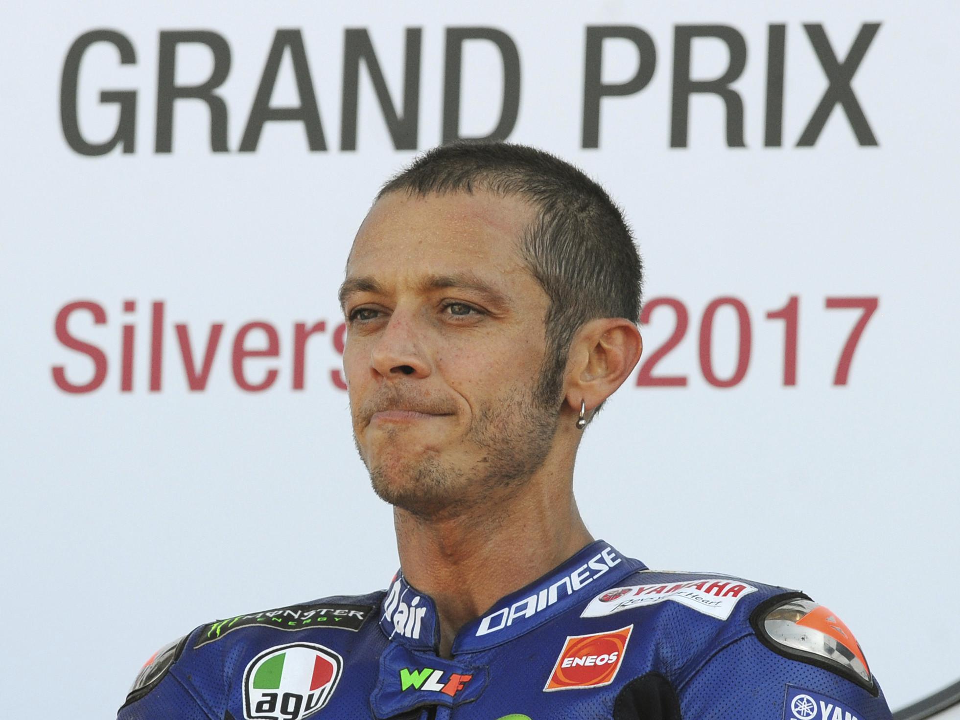 Momen saat pembalap Movistar Yamaha, Valentino Rossi naik podium ketiga MotoGP Inggris 2017 di Sirkuit Silverstone, Minggu (27/8/2017). (AP Photo/Rui Vieira)