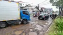 Dinas Bina Marga DKI Jakarta terus berupaya melakukan penanganan darurat dengan menutup lubang-lubang jalan menggunakan material sementara guna menjaga keselamatan pengguna jalan. Tampak dalam foto, sejumlah pengendara melewati kerusakan di Jalan Gedong Panjang, Penjaringan Jakarta Utara, Selasa (3/2/2026). (merdeka.com/Arie Basuki)