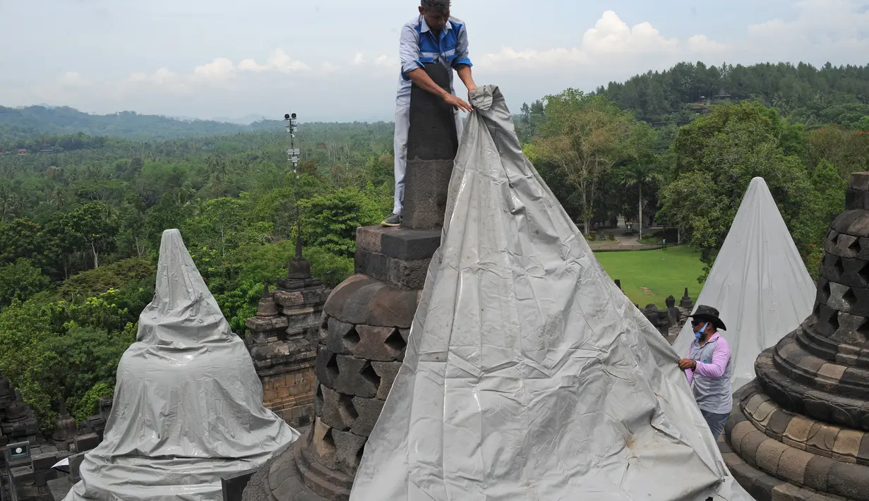 Pekerja menutup stupa di kompleks candi Borobudur, Magelang, Jawa Tengah, Senin (23/11/2020). Penutupan candi Borobudur oleh BKB (Balai Konservasi Borobudur) sebagai langkah antisipasi melindungi batu candi dari abu vulkanik jika Gunung Merapi erupsi. (Photo by Agung Supriyanto/AFP)