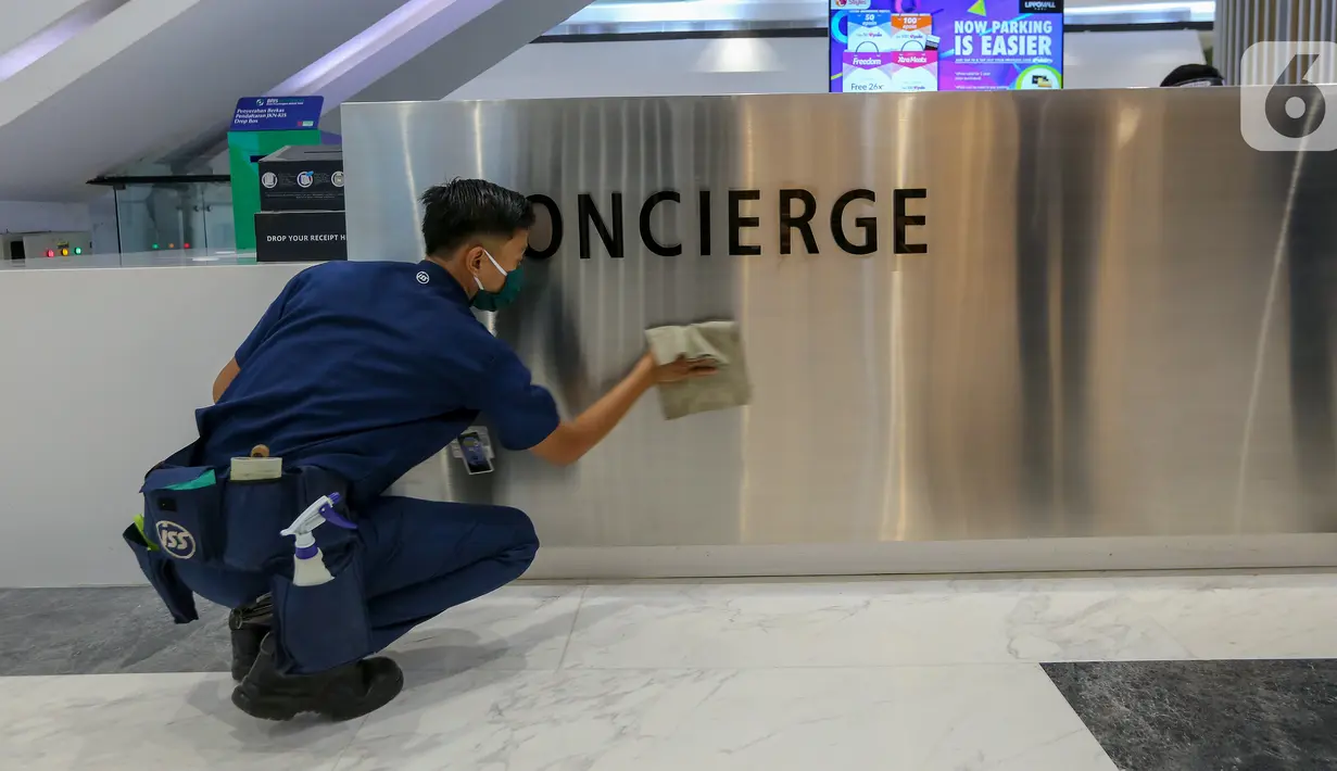 Pekerja membersihkan meja layanan concierge di Lippo Mall Puri, Jakarta, Rabu (3/6/2020). Lippo Malls Indonesia (LMI) menyiapkan prosedur dengan menerapkan protokol kesehatan menuju new normal di seluruh mal di 34 kota besar di Indonesia. (Liputan6.com/Fery Pradolo)
