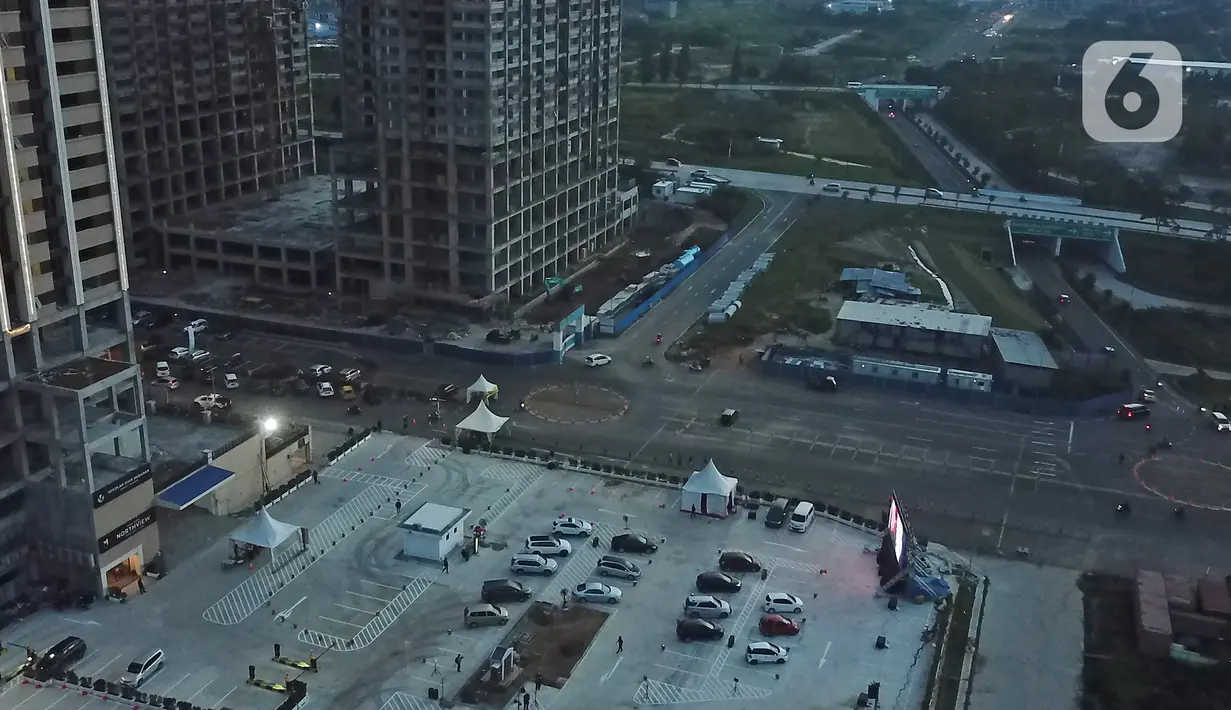 Foto dari udara menunjukkan deretan mobil penonton terparkir saat menyaksikan pemutaran film secara drive-in di Cikarang, Bekasi, Jawa Barat, Rabu (3/6/2020). Jelang new normal, pengelola pusat hiburan menghadirkan konsep gaya hidup dengan standar protokol kesehatan. (Liputan6.com/Herman Zakharia)