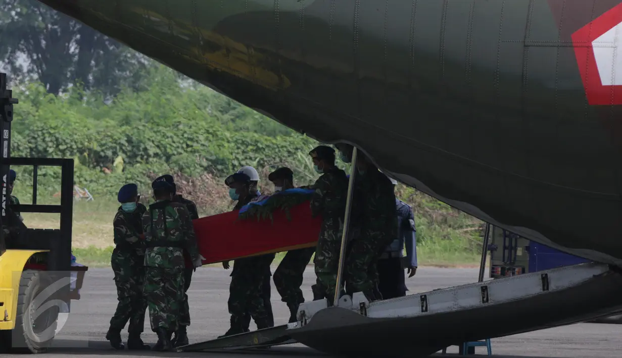 Petugas mengeluarkan peti jenazah dari pesawat Hercules bernomor ekor 1321 ke pesawat pengganti jenis CN 295, di Lanud Soewondo, Medan, Jumat (3/7). Pemindahan tersebut karena muncul percikan api di bagian kokpit Hercules C-130. (Liputan6.com/Johan Tallo)