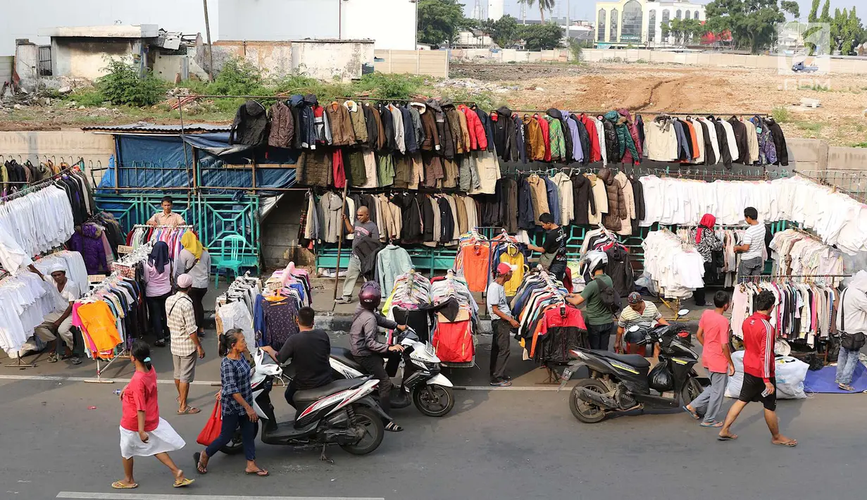 Pedagang pakaian bekas berjualan di sepanjang trotoar kawasan Senen, Jakarta, Jumat (4/5). Belum tersedianya lahan membuat para pedagang menggelar dagangannya di trotoar. (Liputan6.com/Immanuel Antonius)