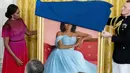 Mantan ibu negara Michelle Obama bersiap mengungkap potret resmi dari lukisannya yang akan menjadi koleksi Gedung Putih di Ruang Timur Gedung Putih, Washington, Rabu (7/9/2022).  Michelle Obama dilukis dengan posisi duduk, dengan mengenakan gaun berwarna biru muda. (AP Photo/Andrew Harnik)