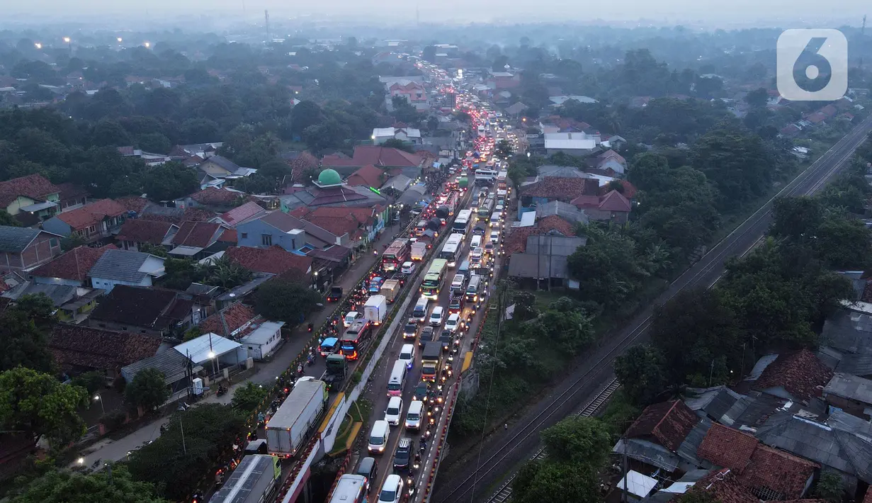 <p>Foto udara memperlihatkan kondisi lalu lintas di Simpang Jomin Pantura, Cikampek, Jawa Barat, Jumat (29/4/2022). Memasuki H-3 Idul Fitri, jalur mudik didominasi oleh kendaraan roda dua, truck dan mobil. (merdeka.com/Imam Buhori)</p>