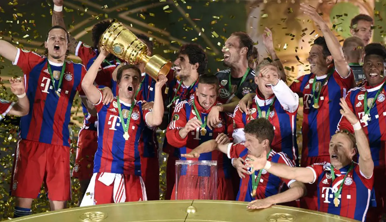 Pemain belakang Bayern München, Philipp Lahm mengangkat trofi DFB Pokal usai menghempaskan Borussia Dortmund 2-0 di Olympiastadion, Berlin (18/5/2014). (AFP PHOTO/Odd Andersen)