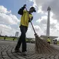 Petugas menyapu membersihkan kawasaan Monas, Jakarta, Senin (1/1). Sebelumnya, kawasan Monas menjadi titik berkumpul warga saat perayaan malam pergantian tahun dan menyisahkan sampah dari pengunjung monas. (Liputan6.com/Faizal Fanani)