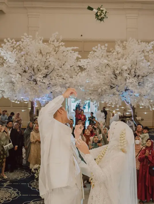 Memes maupun Adya memakai baju pengantin serbaputih. Tidak seperti biasa dengan rambut panjangnya yang indah, saat prosesi akad nikah Memes memakai dress muslimah panjang lengkap dengan hijab. Suasana meriah terasa saat Memes dan Adya melempar buket bunga ke arah para tamu. [Instagram/memes_prameswari]