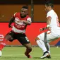 Pemain Madura United, David Laly, berduel dengan bek Persija Jakarta, Tony Sucipto, dalam laga pekan ke-14 Shopee Liga 1 2019 yang berakhir imbang 2-2 di Stadion Gelora Madura, Pamekasan, Jumat (16/8/2019). (Bola.com/Aditya Wany)