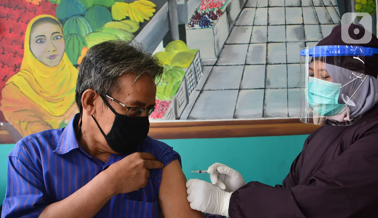 Seorang pedagang melakukan vaksinasi Covid-19  di Pasar Cisalak, Depok, Jawa Barat, Selasa (9/3/2021). Vaksinasi Covid-19 di empat pasar tradisional tersebut untuk mempercepat program vaksinasi yang digaungkan pemerintah. (merdeka.com/Arie Basuki)