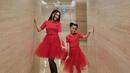 Ibu dan anak ini kembaran pakai dress tulle merah yang dipadukan sepatu boots hitam.