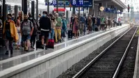 Penumpang berjalan di sepanjang peron di stasiun kereta utama di Frankfurt, Jerman, Jumat (14/8/2020). Mengenakan masker untuk melindungi diri dari corona Covid-19 adalah kewajiban di transportasi umum di Jerman. (AP Photo/Michael Probst)