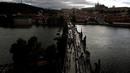 Warga menggelar makan malam di atas meja sepanjang 500 meter di jembatan bersejarah Charles Bridge di Praha, Republik Ceko, Selasa (30/6/2020). Kegiatan itu merupakan perpisahan simbolis yang digelar untuk menandai akhir dari masa krisis virus corona Covid-19 di negara tersebut (AP/Petr David Josek)