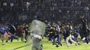 Kericuhan tak terelakkan di stadion yang menjadi markas Arema FC itu. Aremania turun ke lapangan setelah tim kesayangan mereka kalah dari rival bebuyutannya. (AP/Yudha Prabowo)